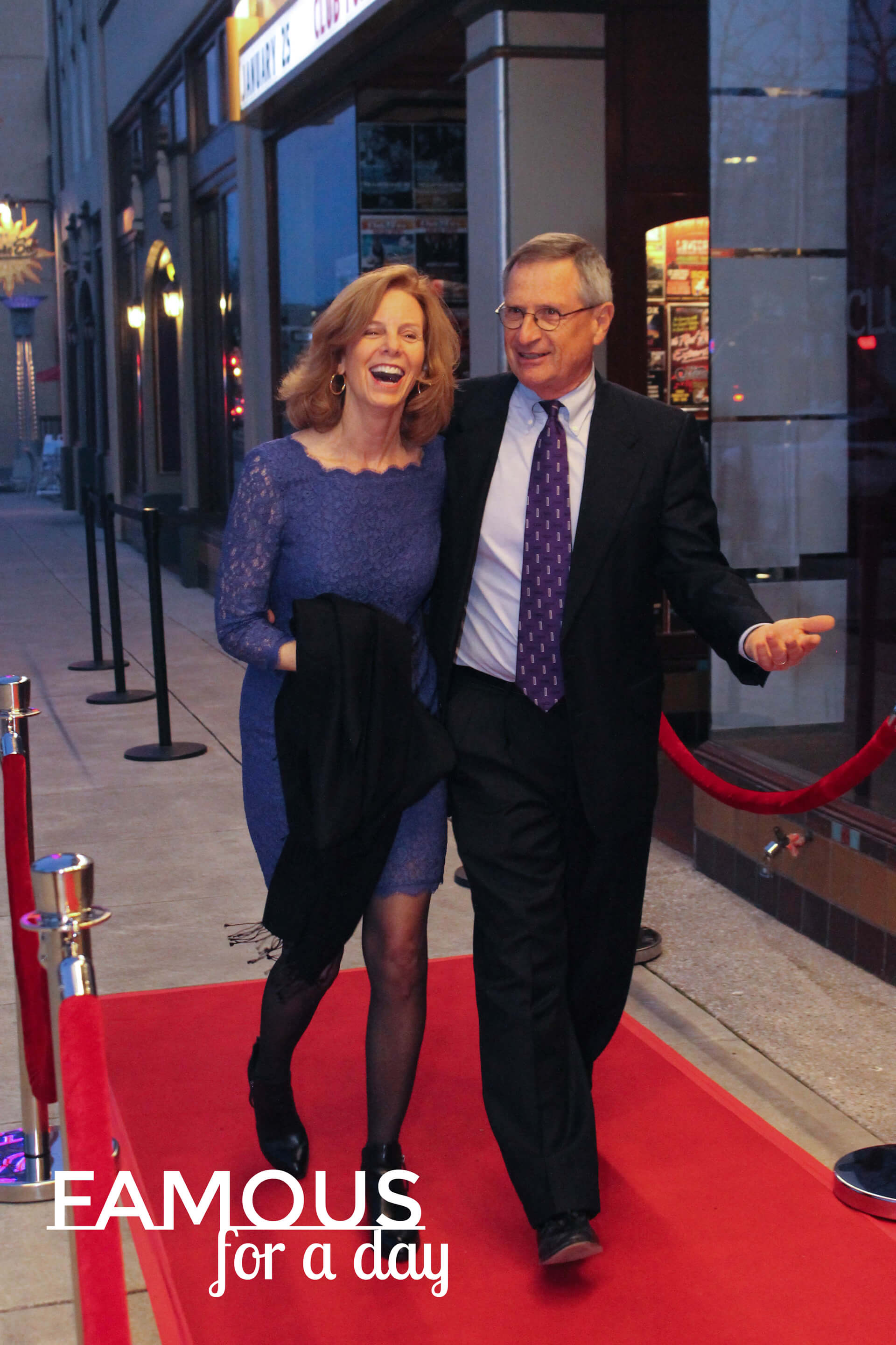 Man in a suit acknowledging photographers while attending a red carpet experience